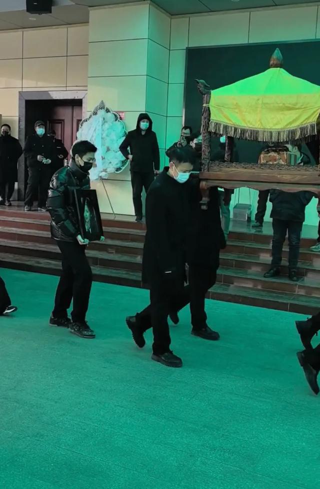 许何弯着腰抱着何晴遗像,背影很难过,许亚军没来给何晴撑伞!