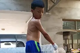 8岁男孩心疼父母，主动帮妈妈搬成箱矿泉水，10万多网友为他竖起大拇指图片