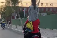 男子骑共享电动车超载带娃 拍摄者：肩上驮一个前面坐一个图片