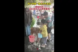 狗子提着一桶水却不会泼，委屈巴巴站在泼水节人群中被泼图片